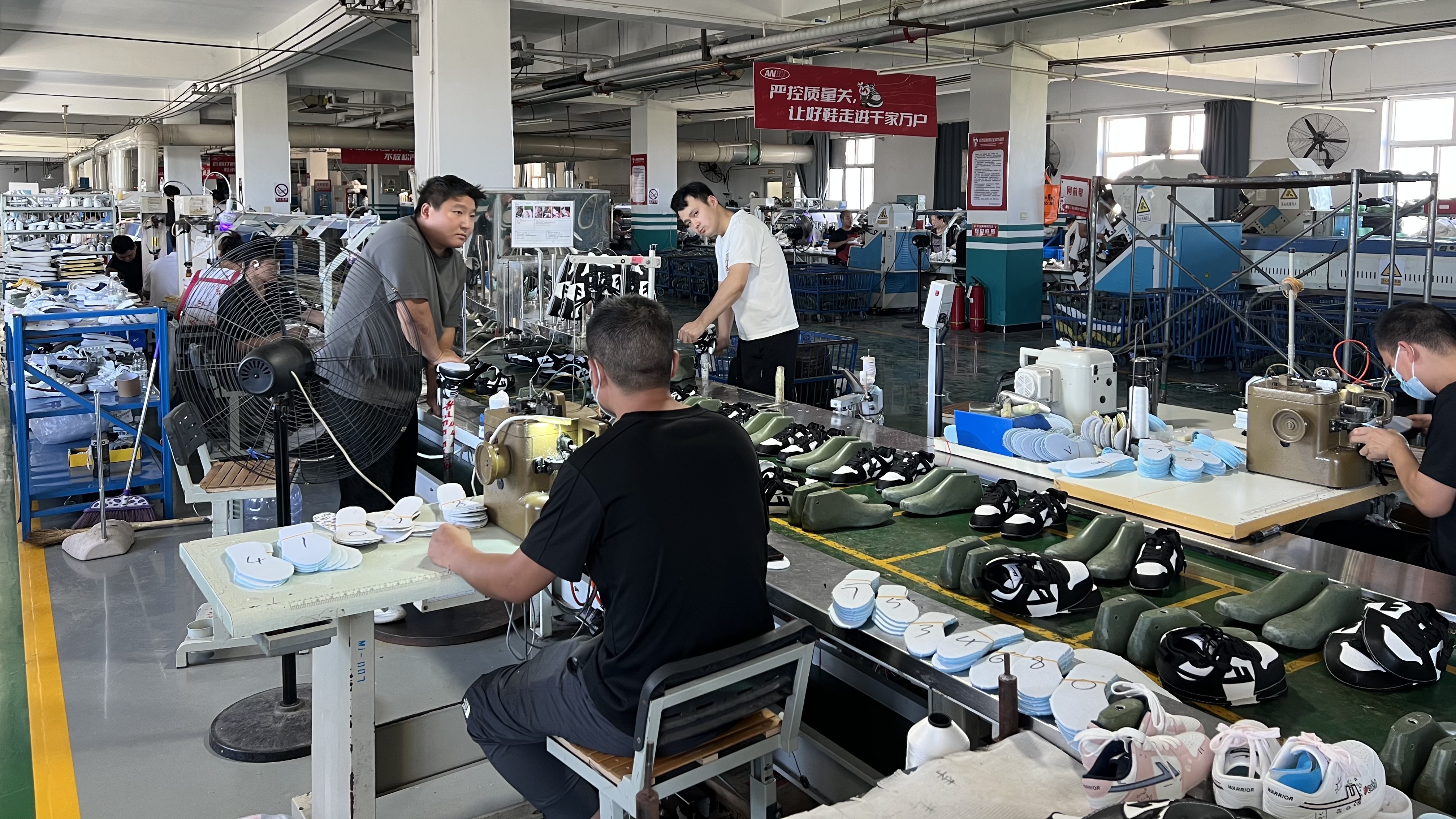 Mingjian Footwear assembly line with lasts, insoles, and technicians at work
